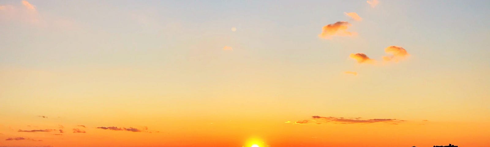 A sunset off the coast of New Jersey from the water.