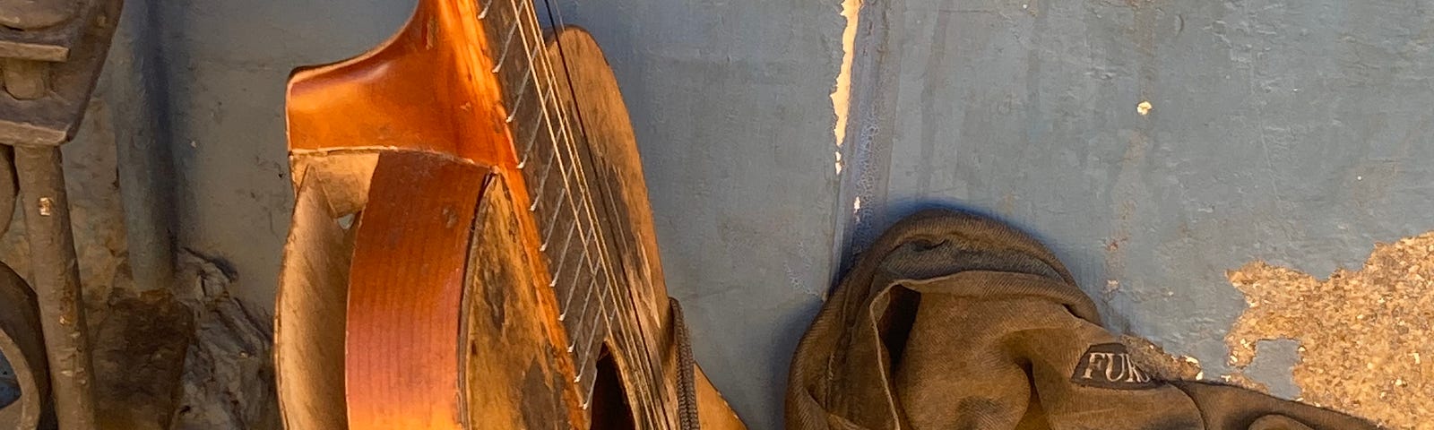 A battered guitar and worn jacket in Oaxaca de Juarez. Photo by Jim Latham © 2021