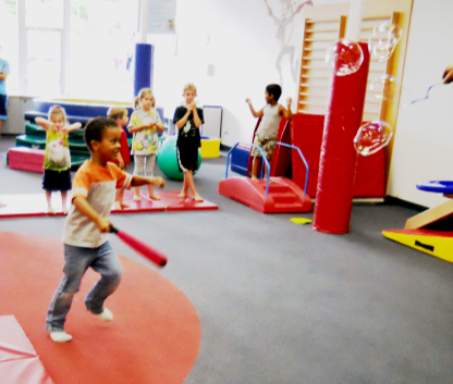 My son swinging at large bubbles with a foam baseball bat.