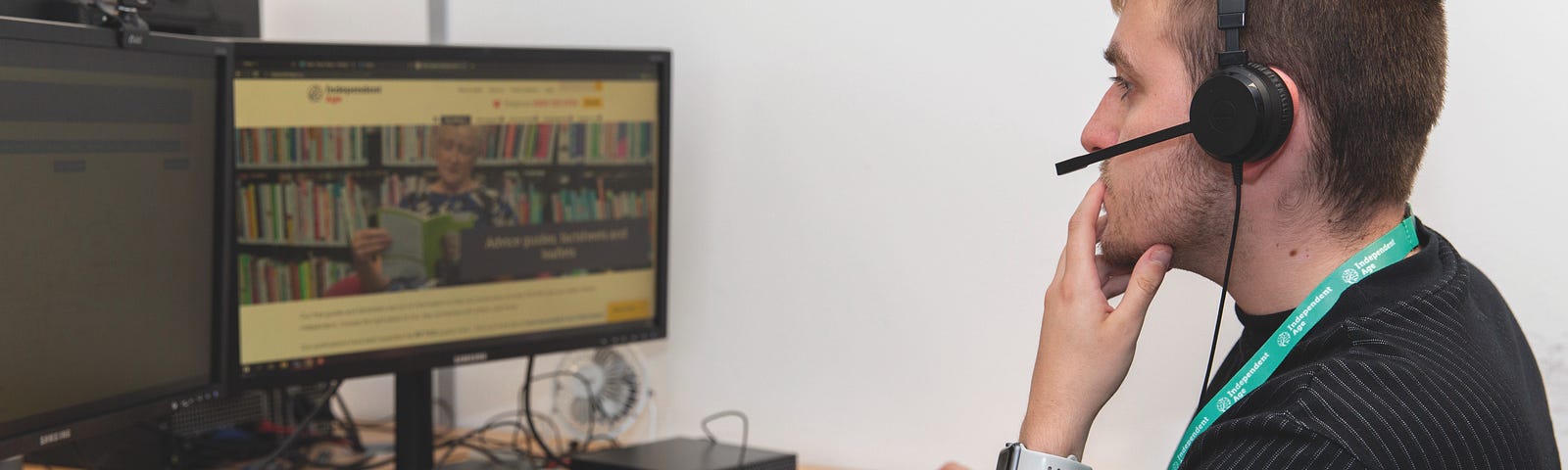 Man sitting at desktop computer wearing a headset