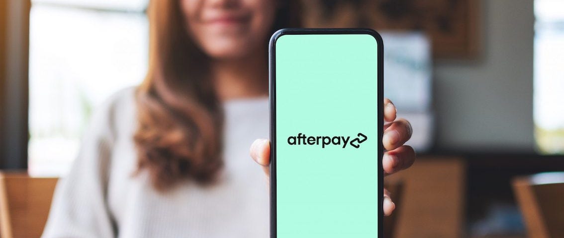IMAGE: Woman showing smartphone with Afterpay logo