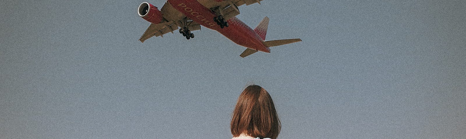 Woman in blue dress watching plane go by