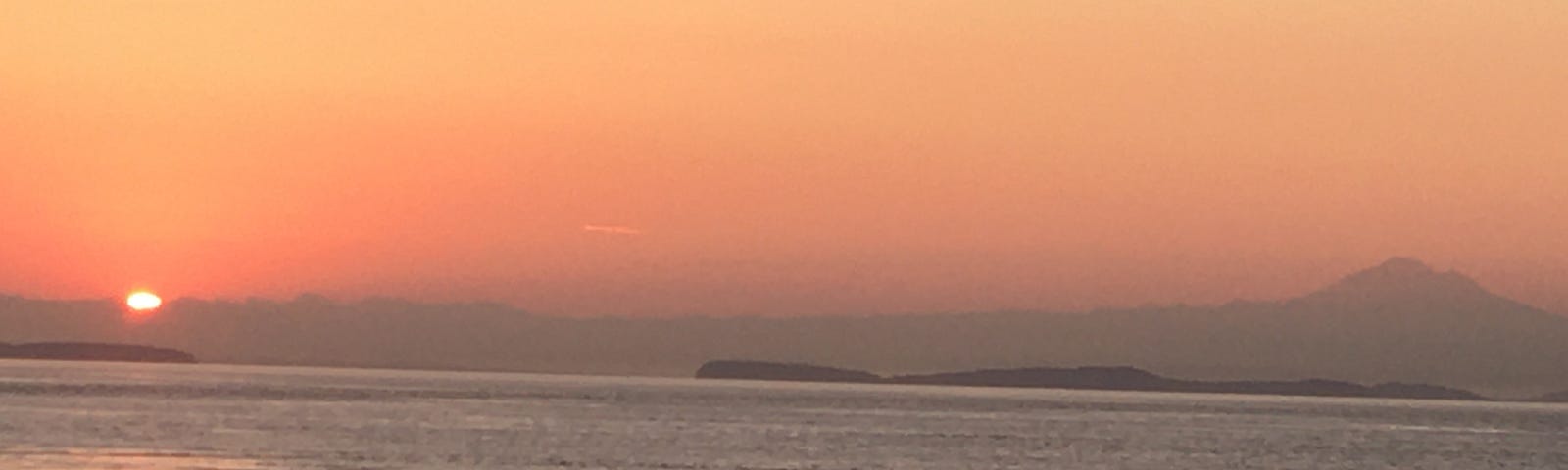 Sunrise over the Cascade Range and the San Juan Islands with Mount Baker on the right.