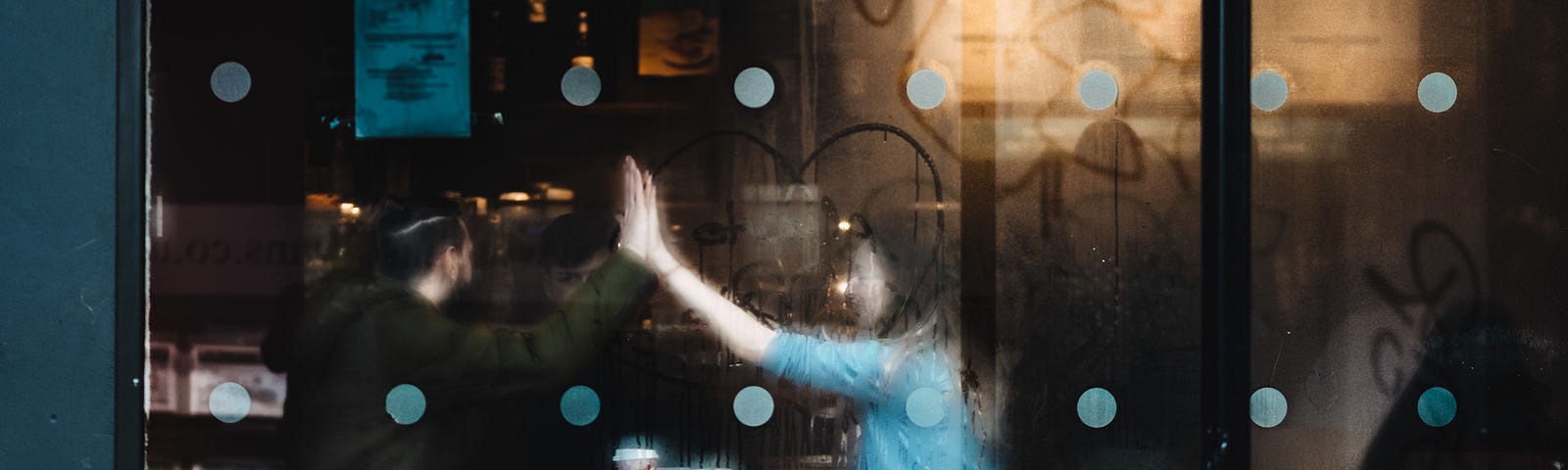 Happy couple in a cafe. High five at each other.