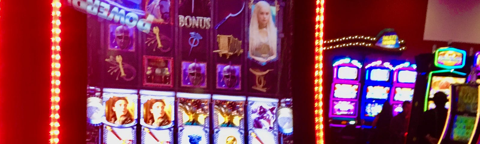 A person sits before a brightly coloured slot machine