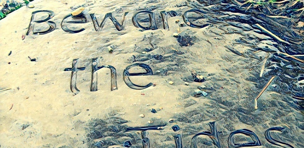 Stone sign reading ‘beware the tides’