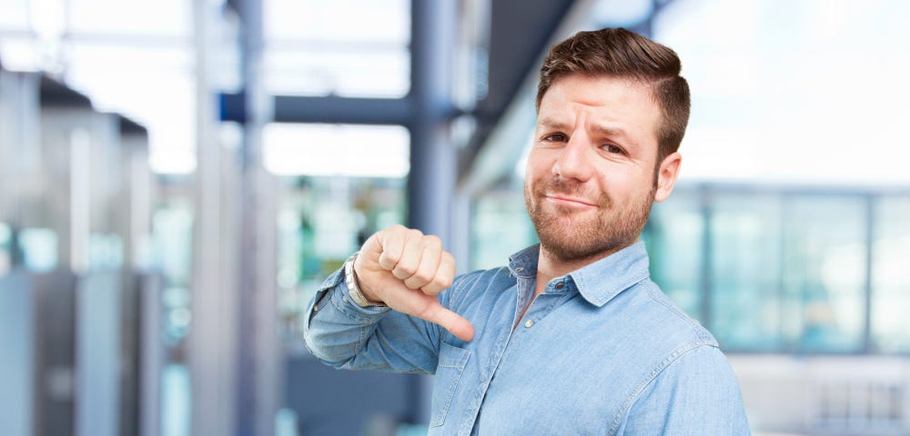 Picture of a happy employee who is pointing his finger at himself.