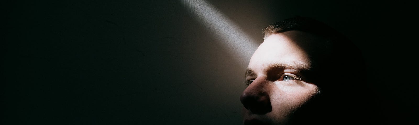 Man in a dark room with one ray of light