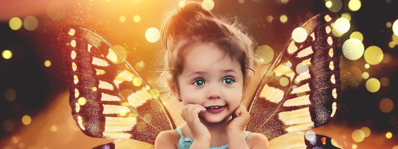 Little girl in blue dress with butterfly wings, hands on face, eyes wide open in wonder, surrounded by sparkles of light.
