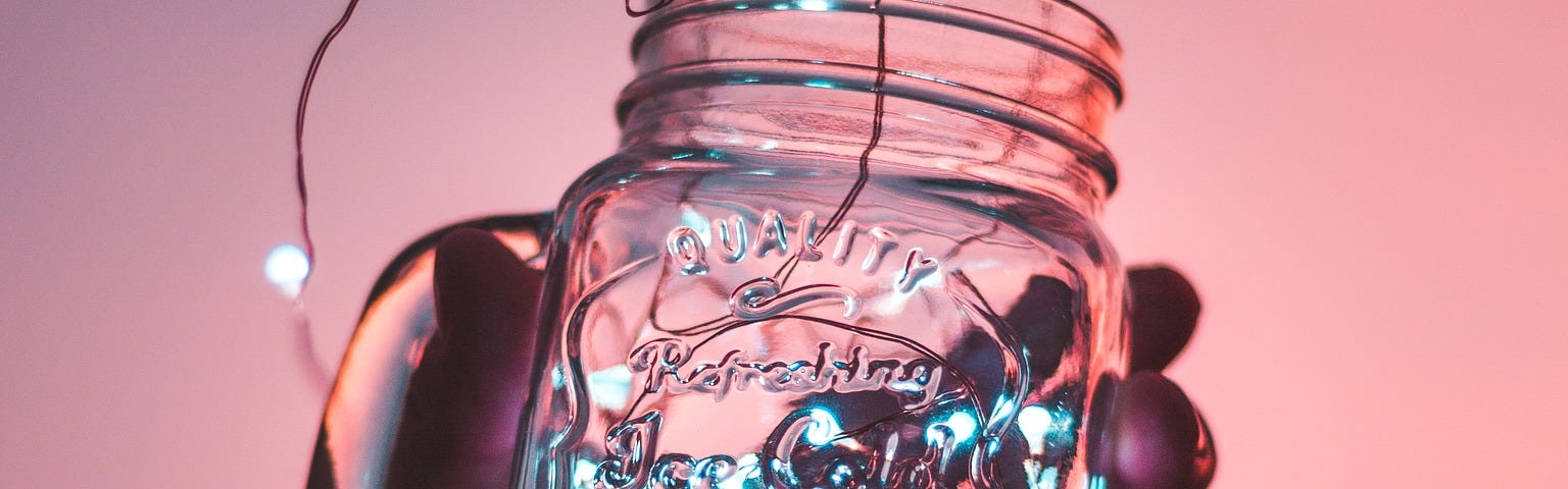 hand holding a mason jar with twinkle lights