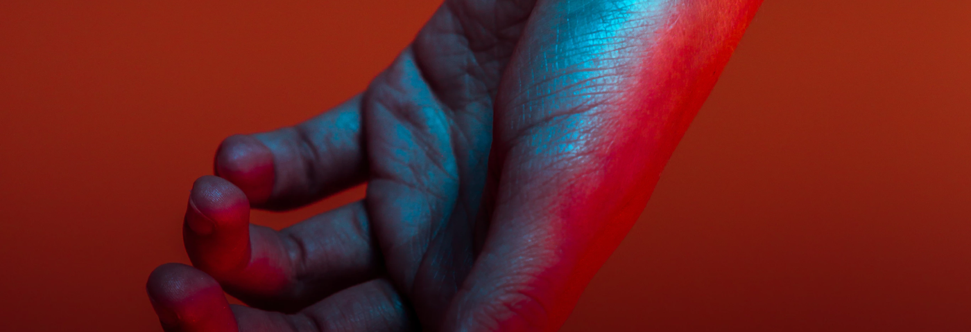 A hanging hand against a red-orange background.