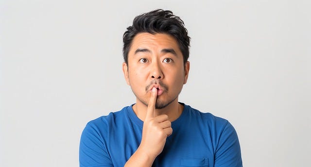 A man with a pensive look tapping his mouth with his index finger