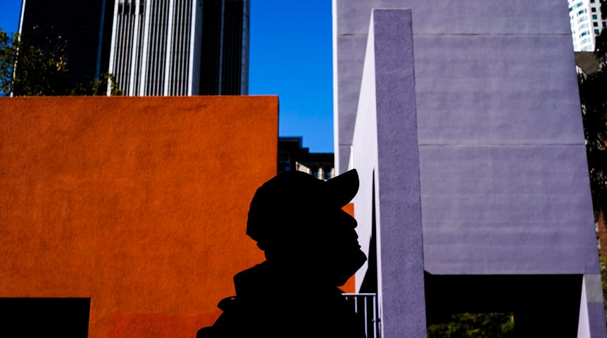 Silhouette of a man in front of bright orange and purple buildings