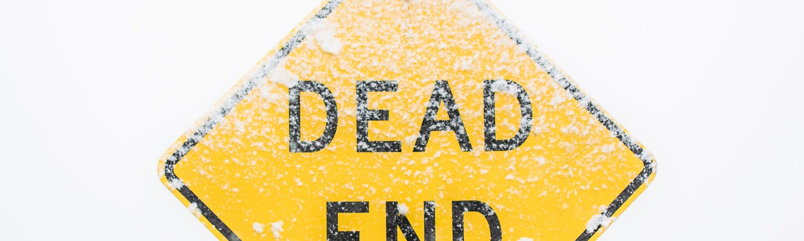 Yellow “DEAD END” road sign with a dusting of snow.