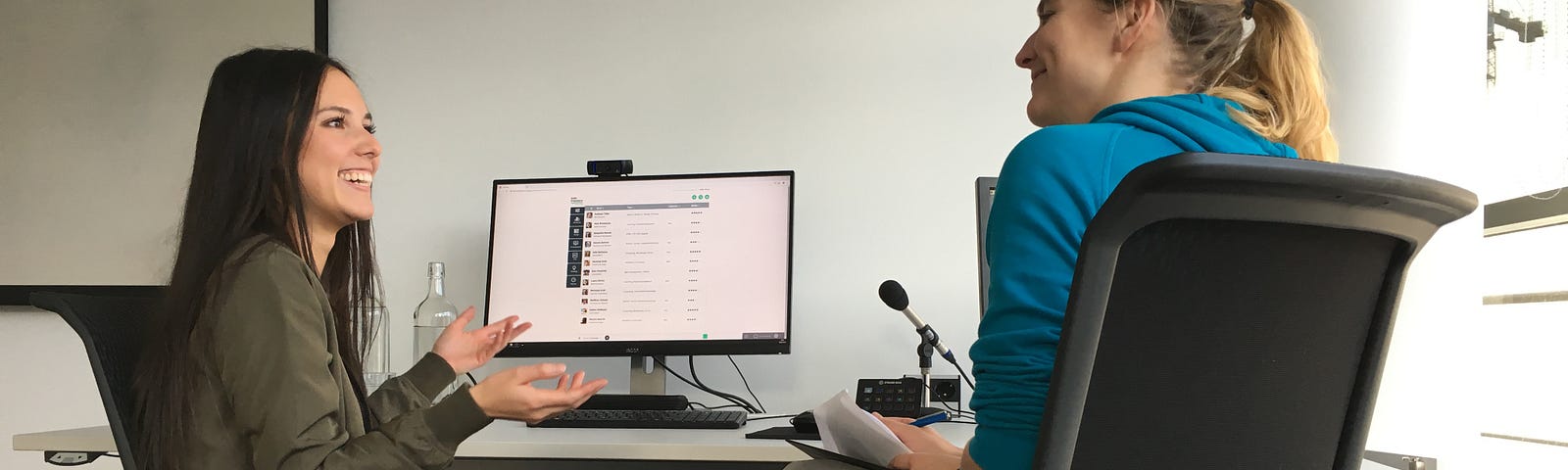 A user researcher and a test user talking in an interview situation in front of a computer.