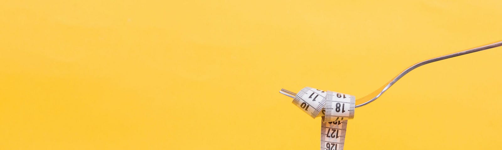 A tape measure wrapped around a fork.