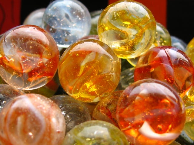 a group of orange, yellow, and blue colored glass marbles