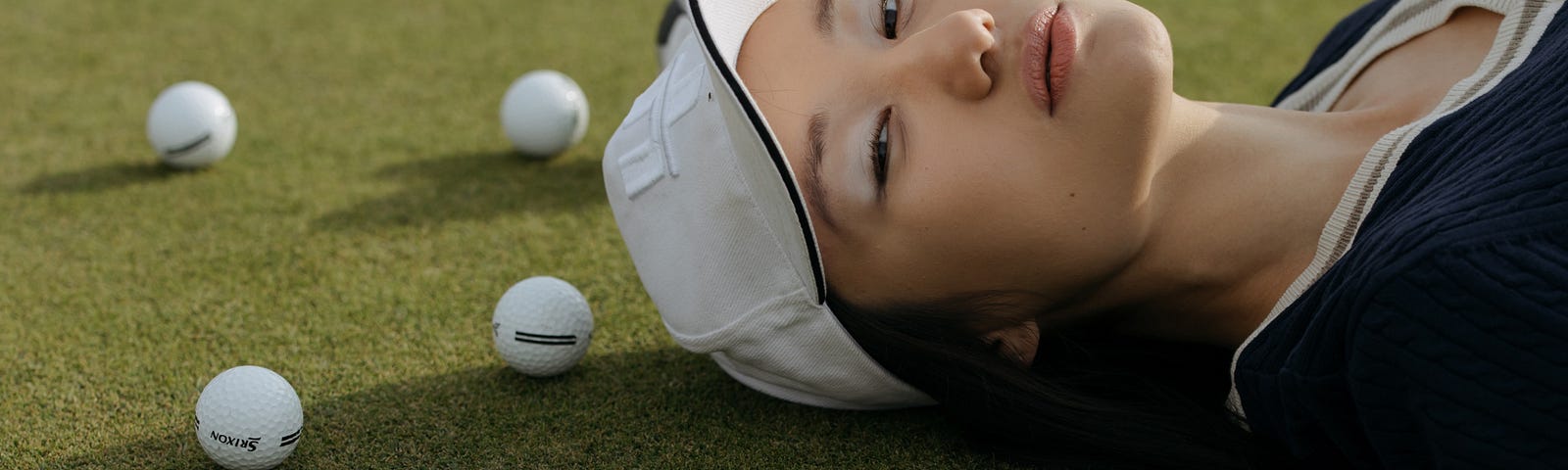 Woman lying by golf balls