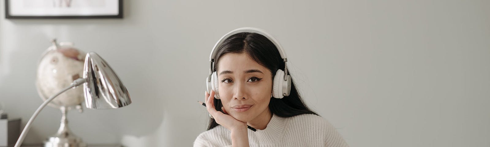A woman with a headset sit in front of her Mac