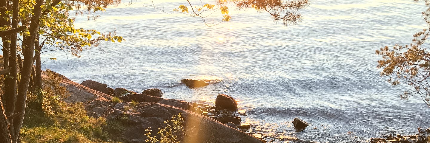 My camping tarp sits perfectly placed on the edge of the Oslofjord, looking out over blue waters into a perfect sunset.