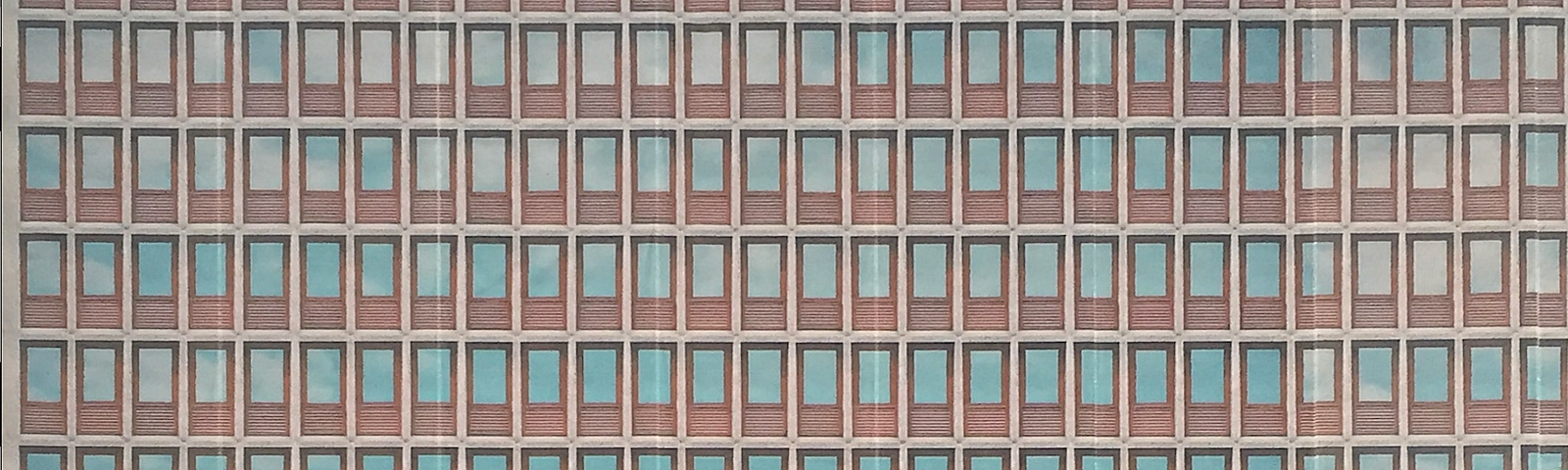 A generic, statist building with brown window frames, uniformly designed.