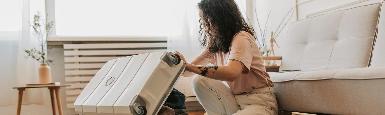 Woman packing her a carry-on suitcase.