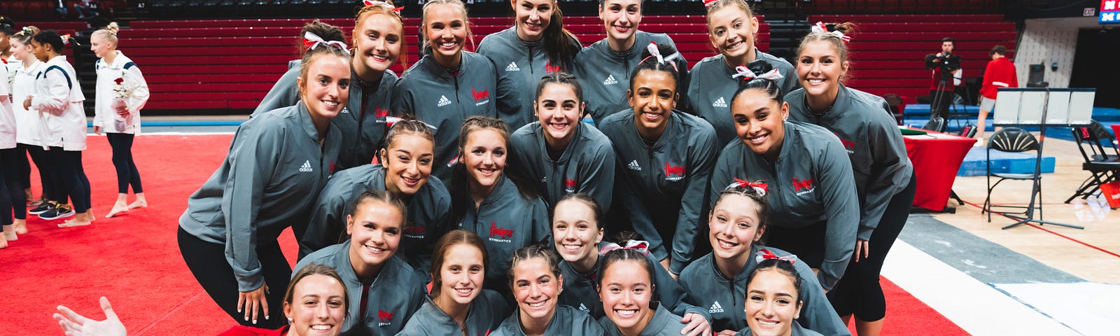Charlotte smiles for a photo with the women’s gymnastics team