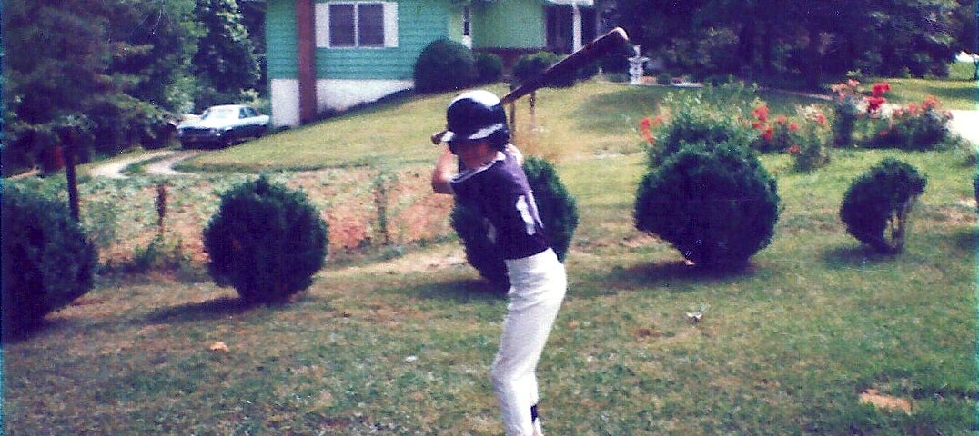 Young boy in a baseball uniform poses in a batting stance
