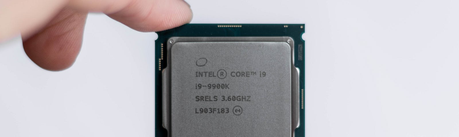 two fingers holding a CPU