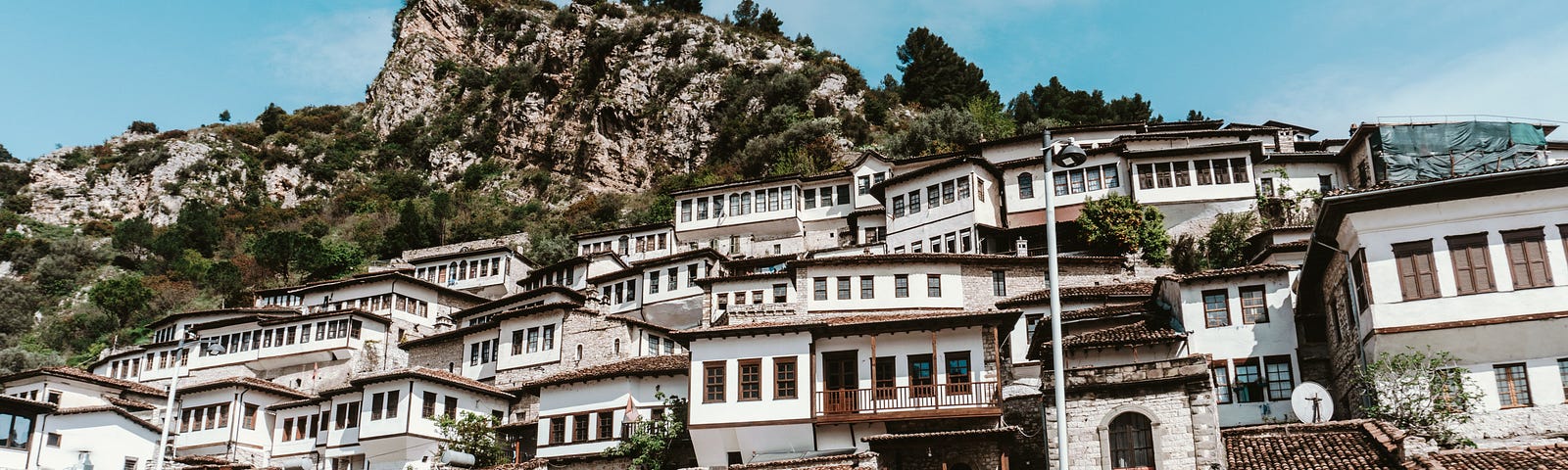 blue car parked while concrete buildings in Albania