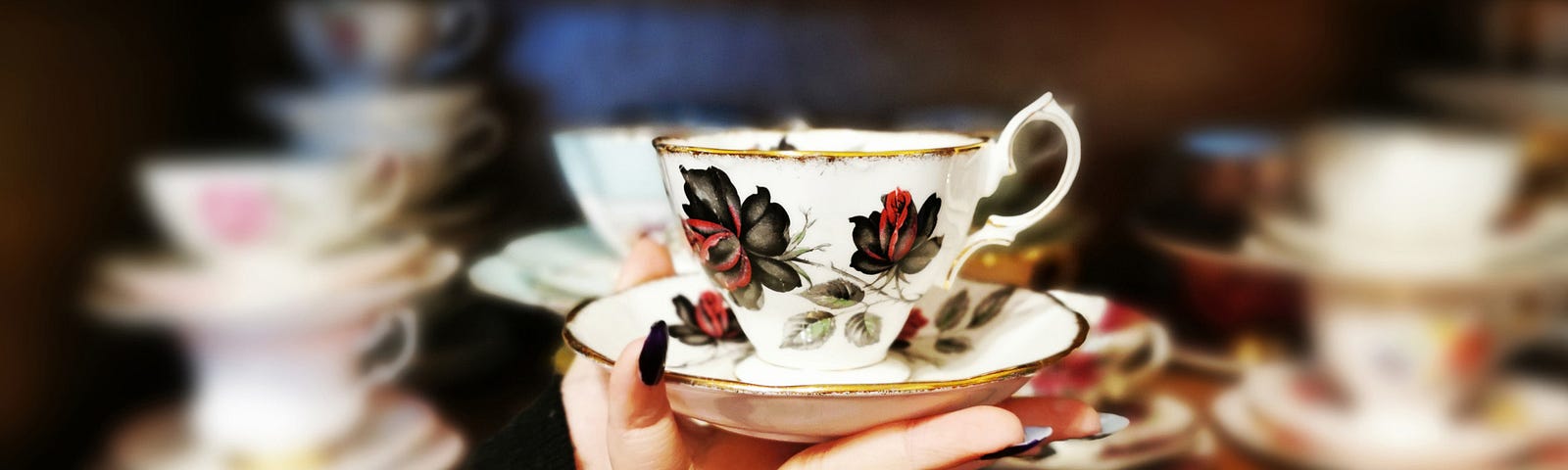 Author holds vintage Royal Albert Masquerade Tea Cup in hand.