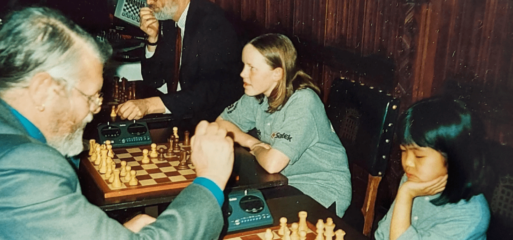 Female child playing against older male in chess