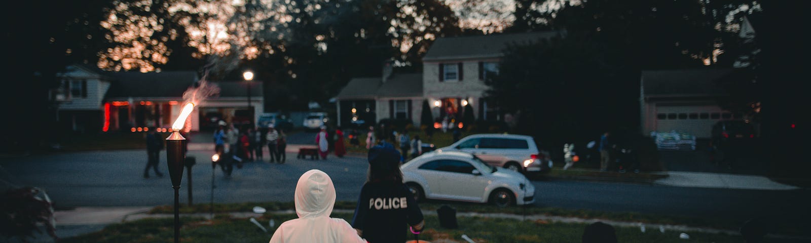 two children running in their neighborhood, on Halloween