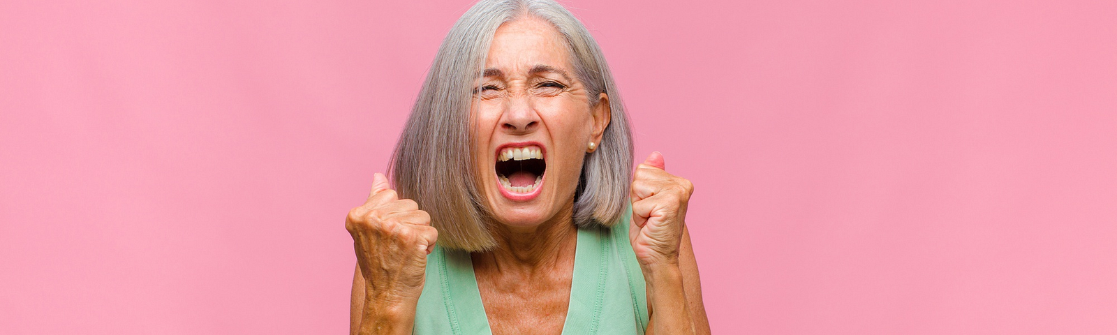 Middle age woman with beautiful grey hair screaming in anger