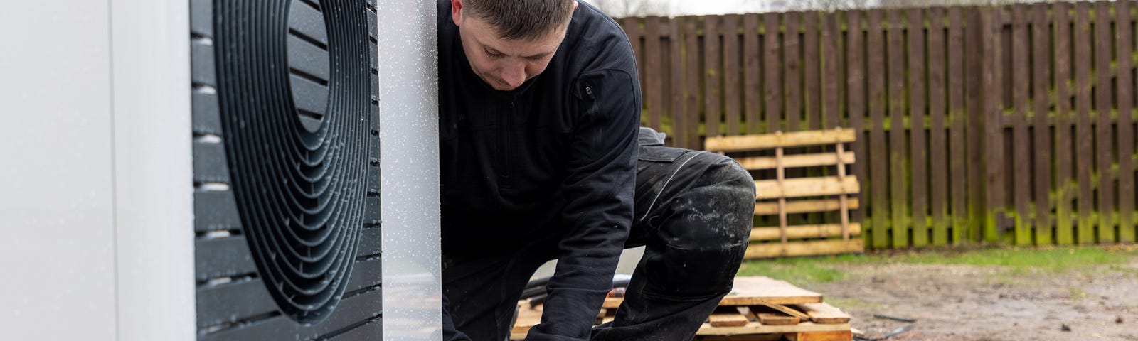 Image shows a heat pump installer working at a domestic property in Glasgow.