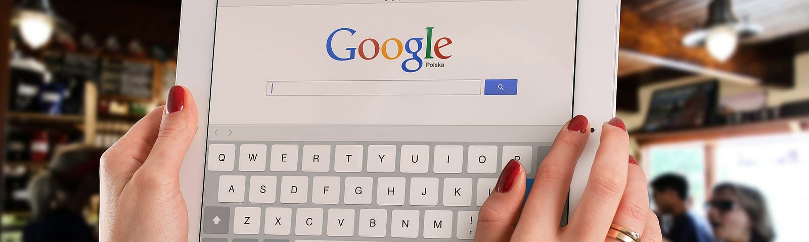 Woman holds up iPad with Google search page visible.