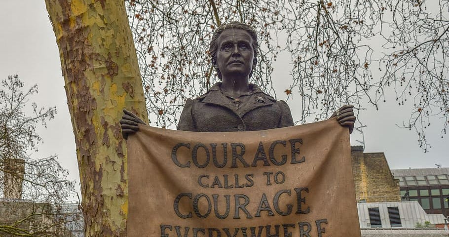 Statue of a women holding a banner that reads “Courage calls to courage everywhere”