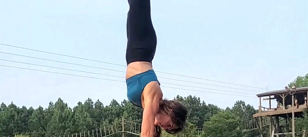 This photo is of me executing an acroyoga move called a standing hand-to-hand, which is where the flyer (me) performs a handstand on a base’s hands. The base is standing up.