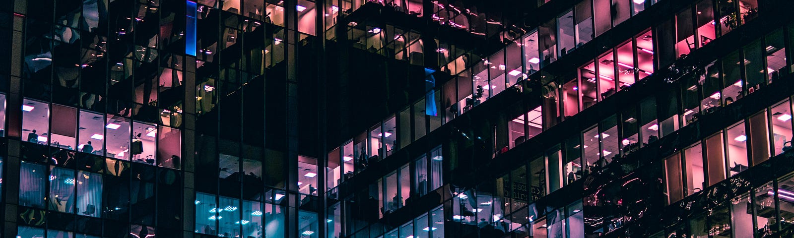 An office building at night with workers in their cubicles