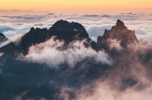Mountain peaks rising above the clouds at dawn