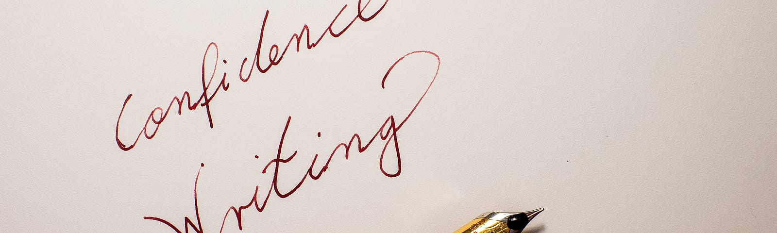 Confidence Writing: a sheet of paper with a dip pen and the words confidence writing written next to the pen in red ink. Oberhausen, Germany, November 25, 2023.