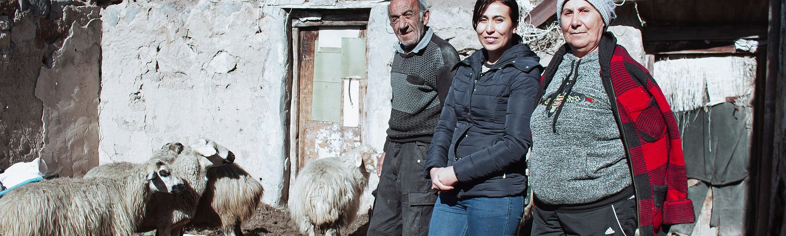(from left to right) Gurgen, Roza, and Luba Serobyan stand in front of their new house in Mets Masrik, Gegharkunik Province