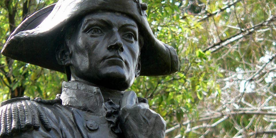 Closeup, bronze statue, Flinders with pensive look on his face, right arm raised selfconsciously to his chest