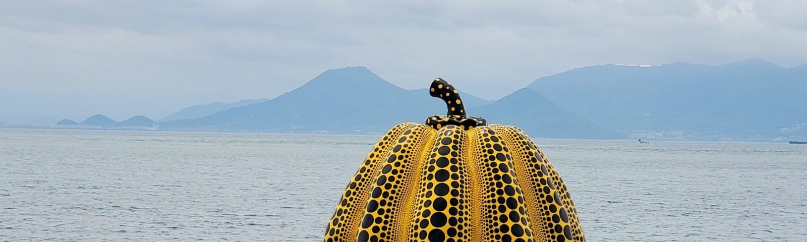 A sculpture of a pumpkin by the sea