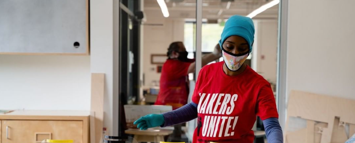 Volunteer assembling the parts of a 3D-printed face shield together