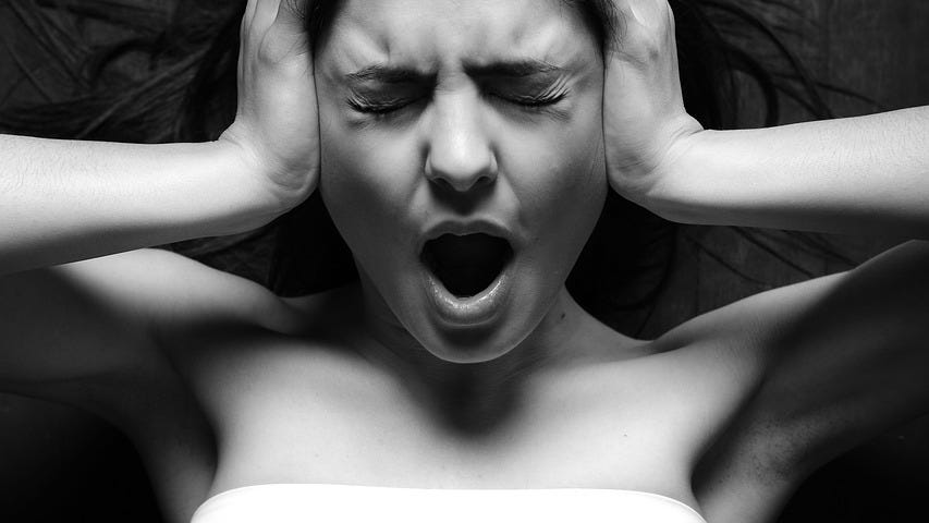 Monochrome image, young woman, hands on the side of her head, scream, anguish, frustration