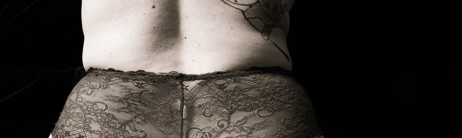 Black and white image of me taken from behind, wearing panties that show my bottom.