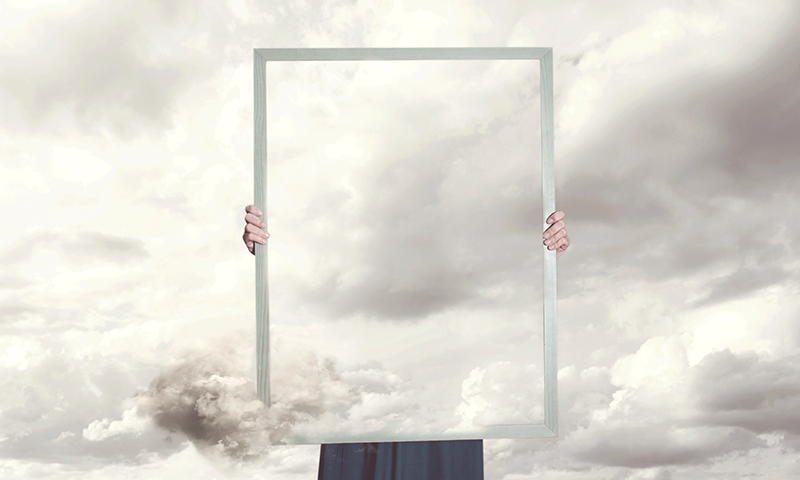 Capton: Surreal moment of a woman hiding behind a picture of clouds equal to the landscape. Credit: fcscafeine/iStock.com