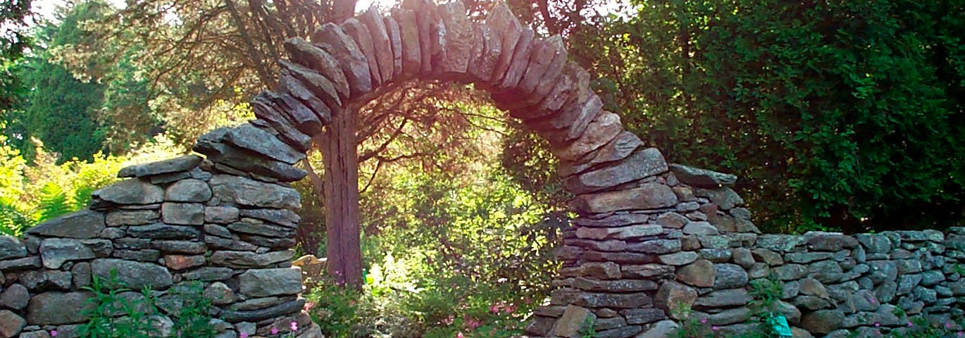 A stone circular entry to a garden