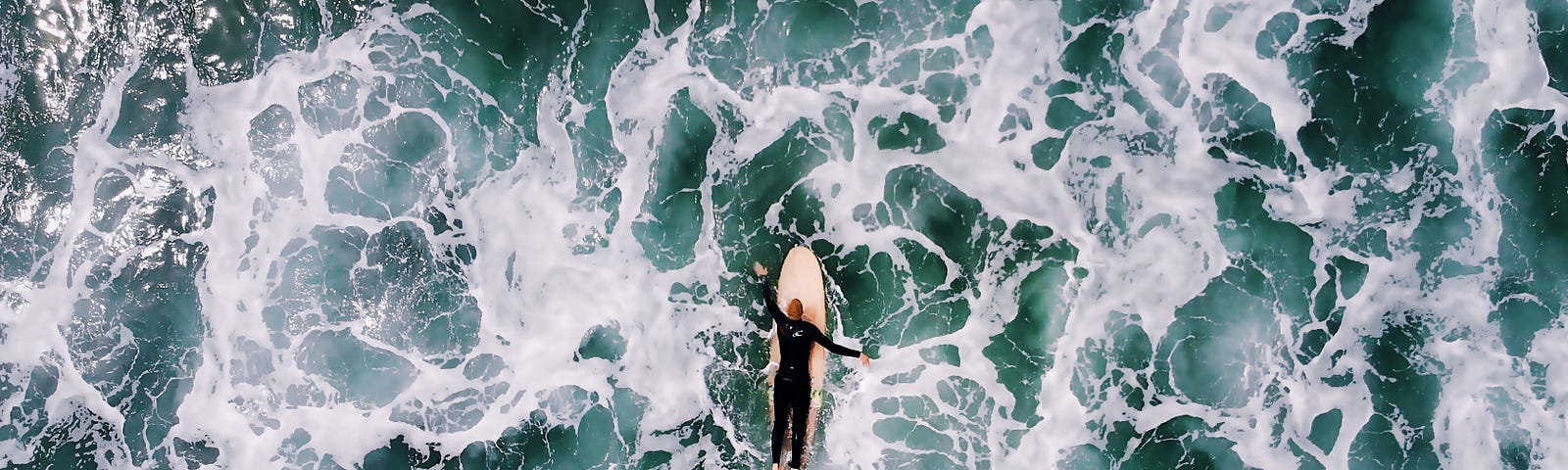 surfer paddling through turbulent water